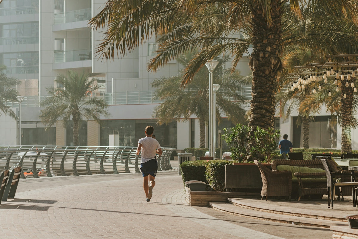 A man running down a street next to palm trees