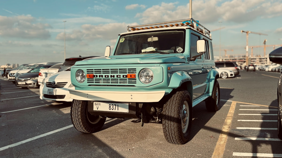 Turquoise vintage suv parked in a lot