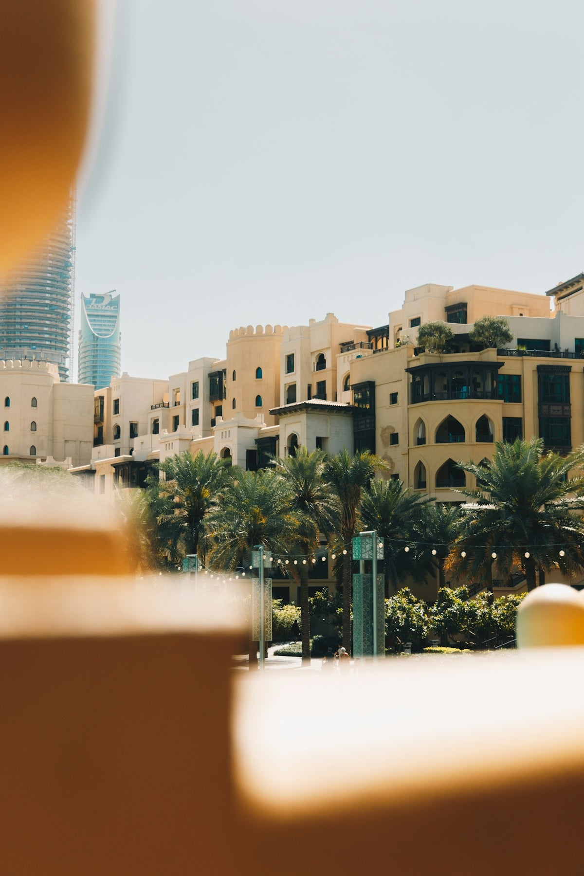 Traditional buildings with palm trees and modern skyscraper