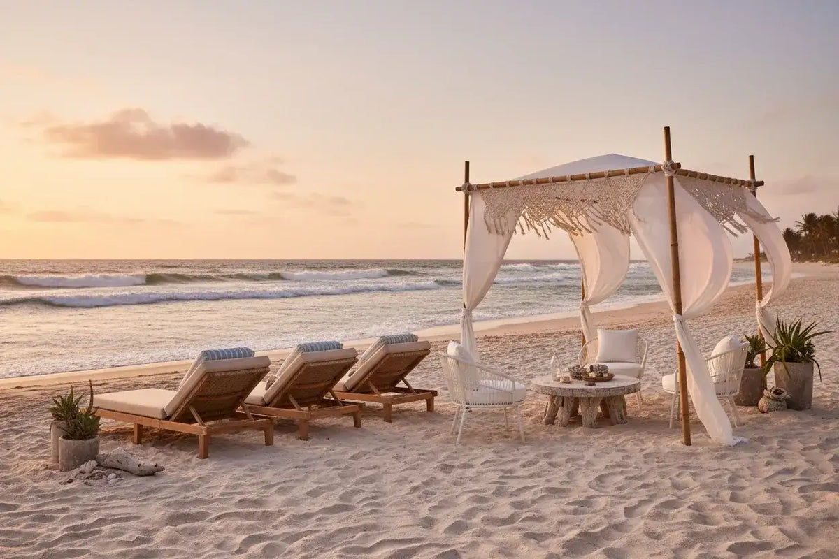 Luxury beach cabana and wooden lounge chairs on a sandy shore at The Outdoor Furniture Market.