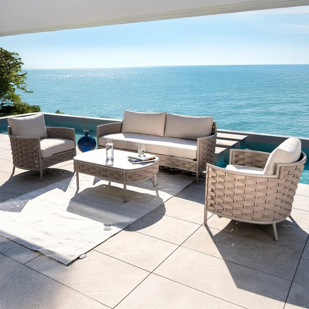 5-seater outdoor aluminum sofa set with woven rope, waterproof cushions, and matching coffee table by the ocean.