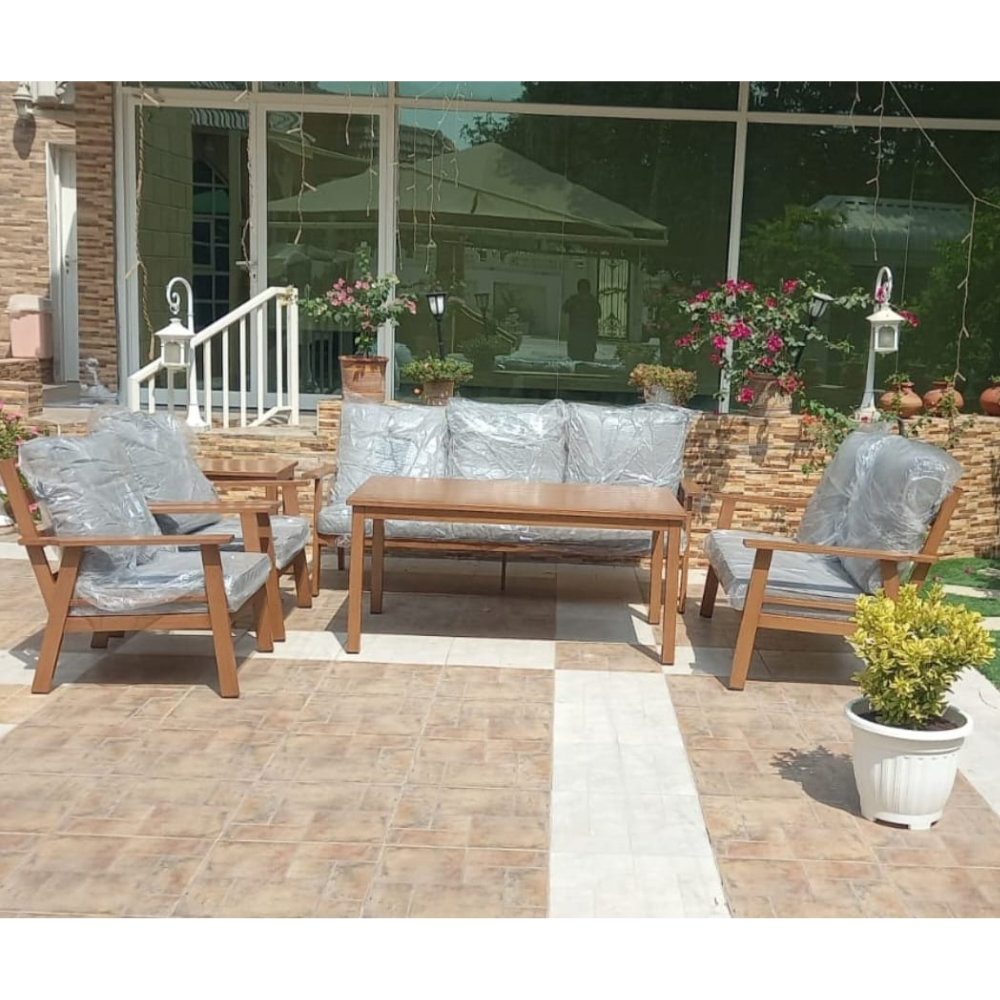 Wooden outdoor patio furniture set with cushions on a tiled terrace at The Outdoor Furniture Market