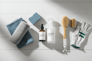 Outdoor furniture cleaning kit with spray bottle, microfiber cloths, and brush on white surface