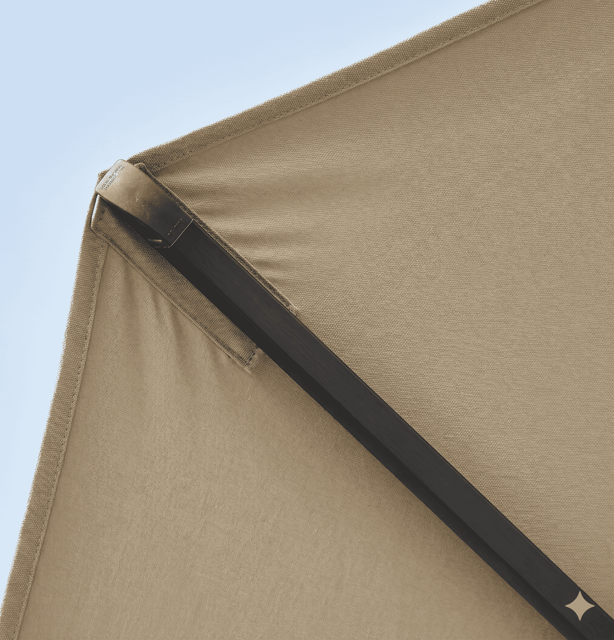 Close-up of a beige tent corner with a clear blue sky background