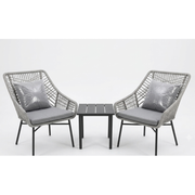 Grey woven outdoor lounge chairs with cushions and a small side table at The Outdoor Furniture Market